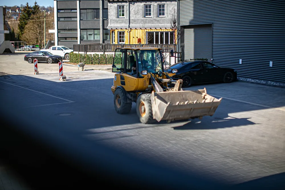 Radlader auf der gepflasterten Hoffläche vor einem Gewerbegebäude